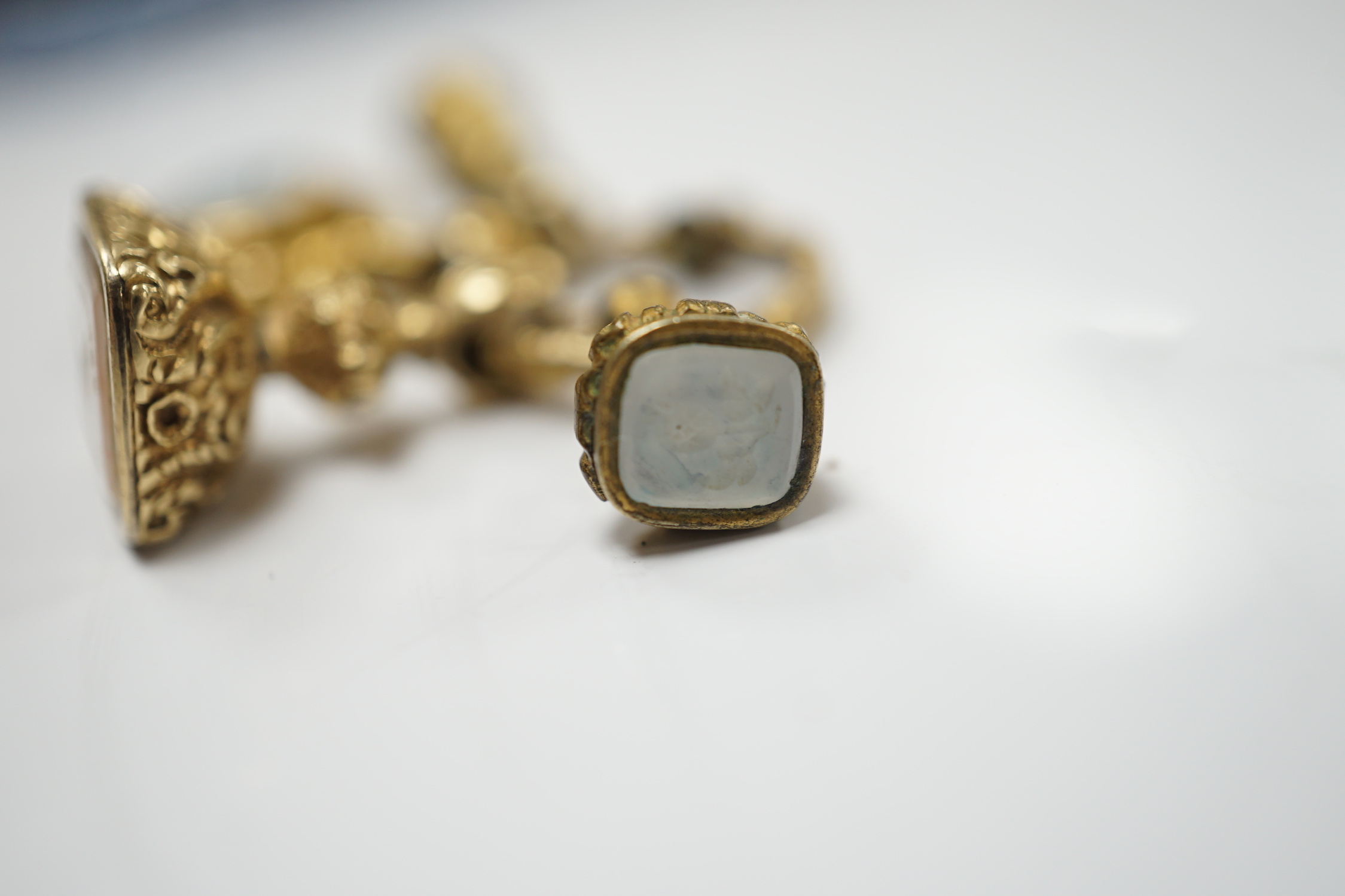 Three assorted 19th century yellow metal overlaid and chalcedony set fob seals and one other item, all mounted on a loop ring, largest approx. 20mm.